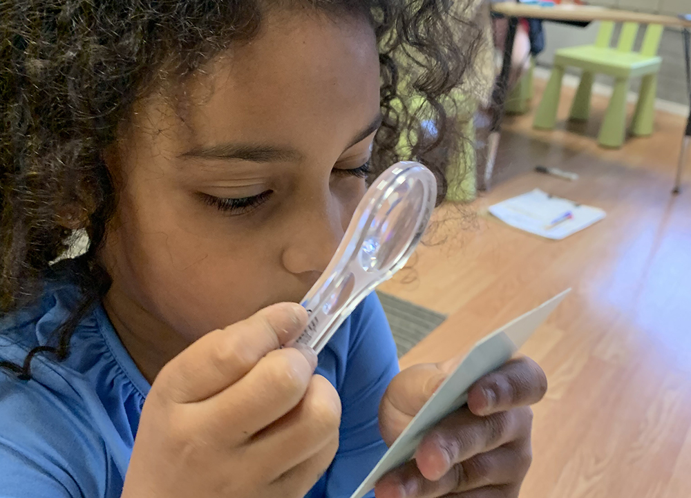 Image of child looking closely at a teaching card at Yadkin Valley Montessori language arts classes